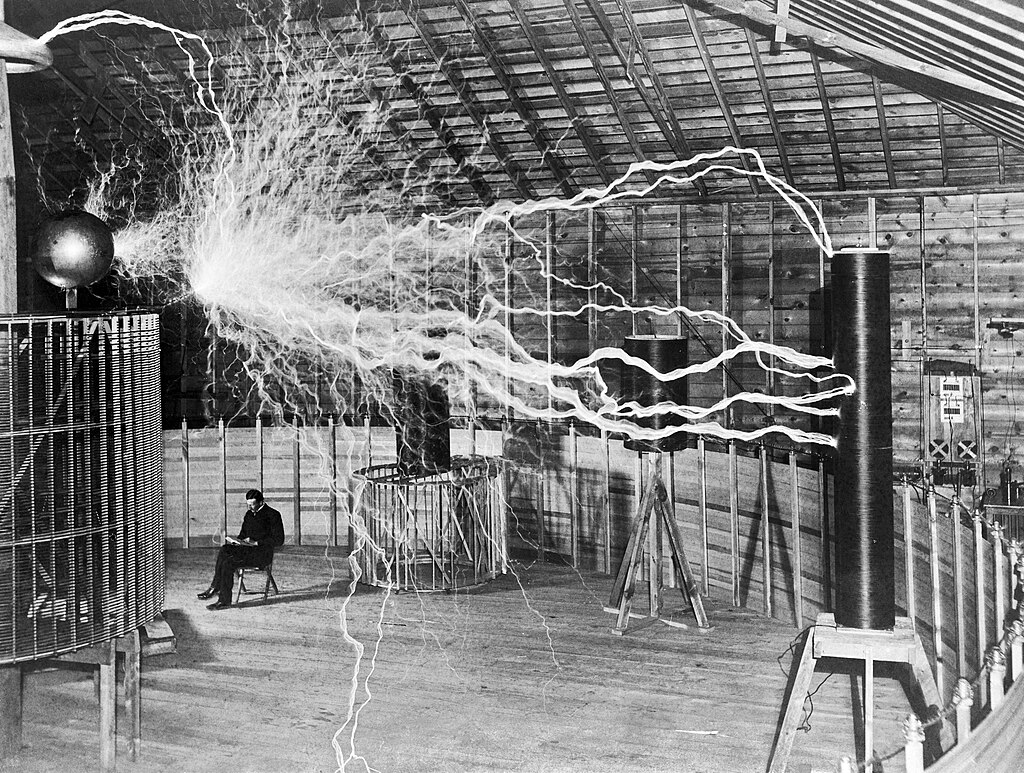 Tesla sits with his "magnifying transmitter" in Colorado Springs in 1899.