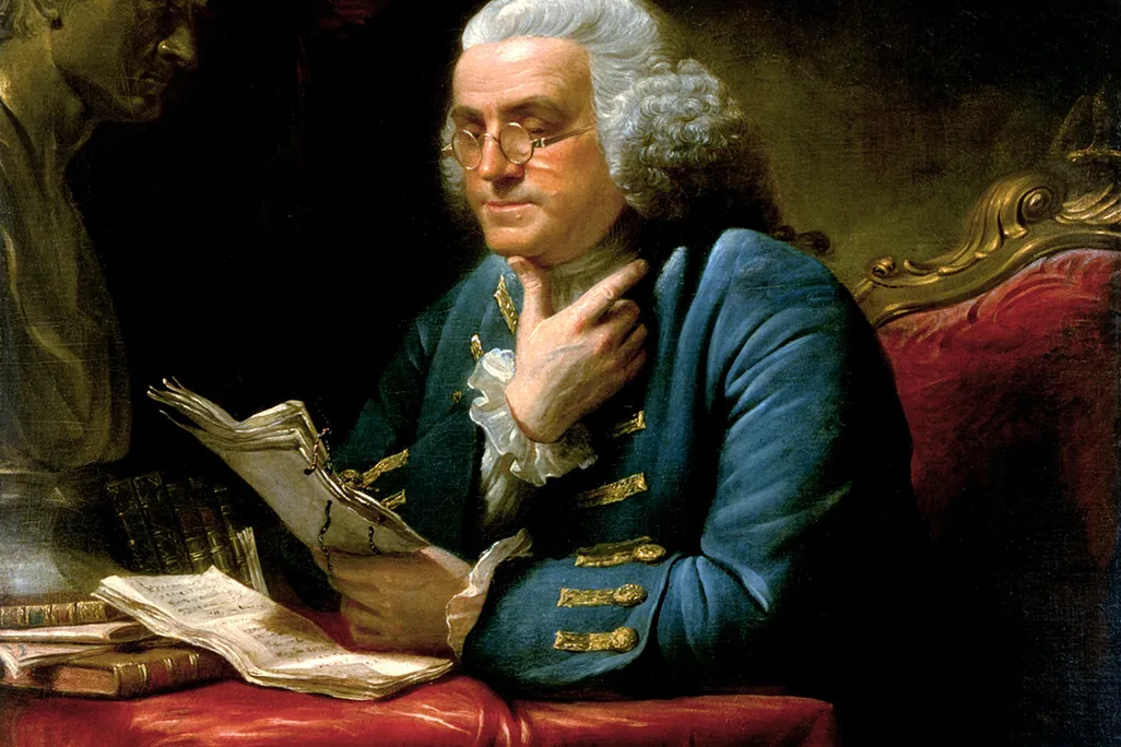 Benjamin Franklin concentrating at a desk