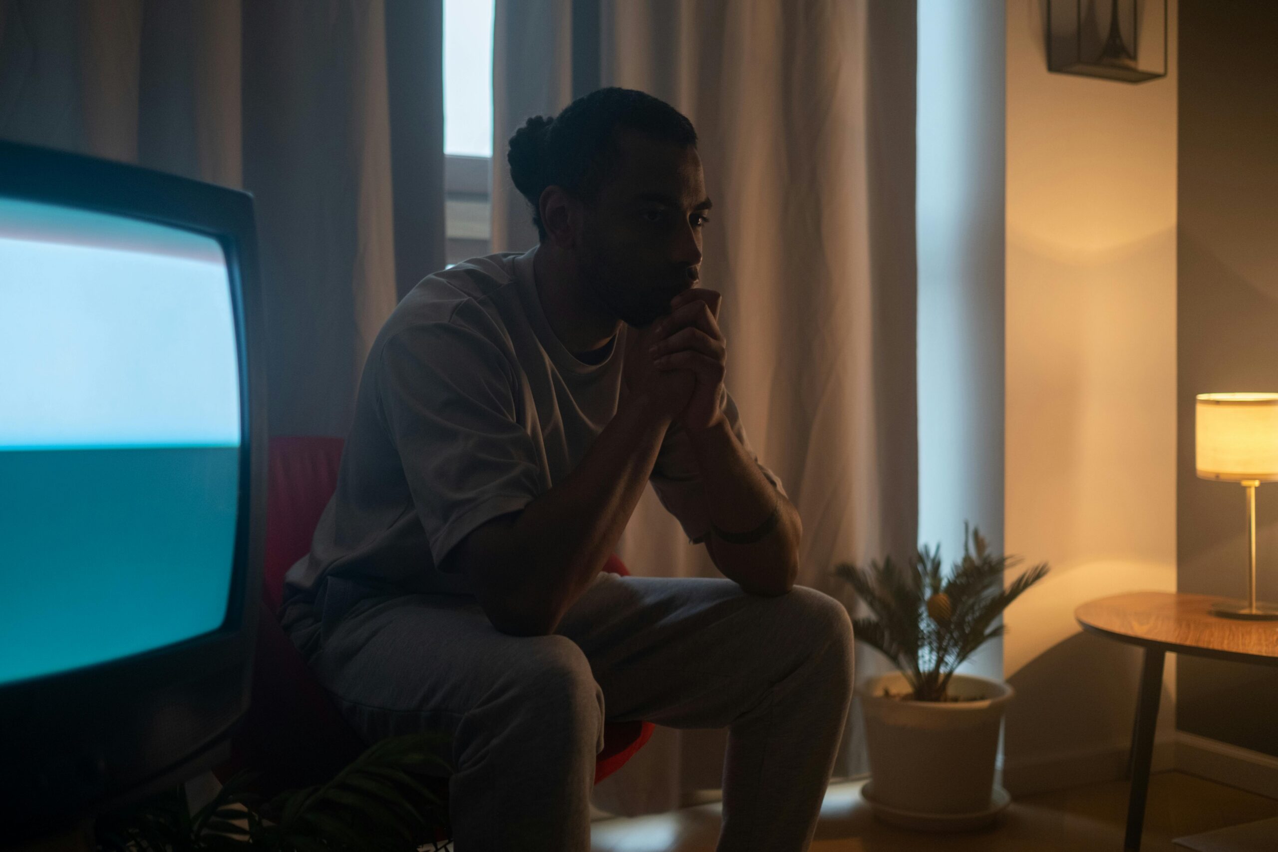 Man sitting up at night with television.