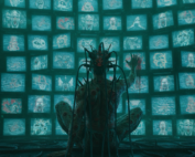 Person sitting alone with multiple screens glowing around them